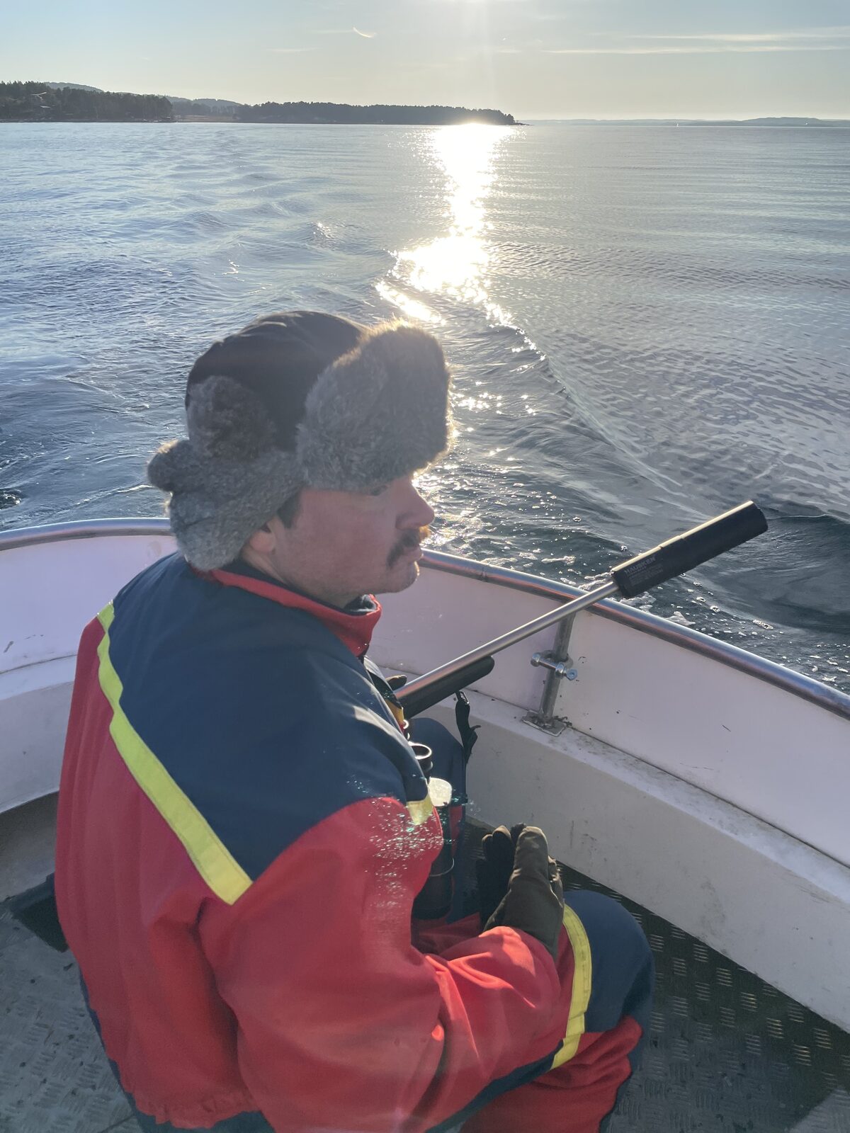 Utsikt fra en liten båt på blank sjø