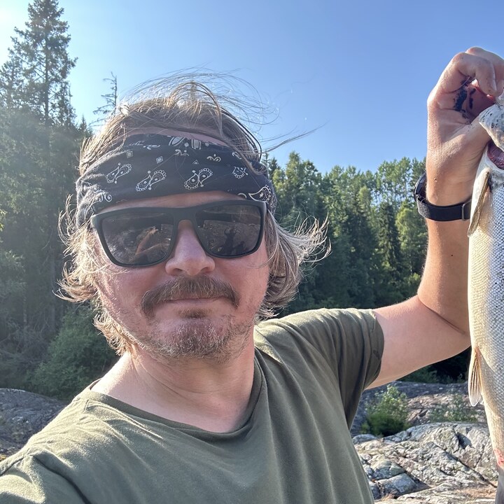 Lars Eirik Reite Steinsvik med en nyfanget fisk ute i naturen